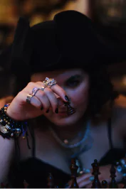 Selena dressed as a pirate, holding a chess piece at the Renaissance Faire