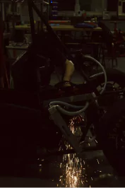 Photo of Owen using an angle grinder on the electric car.