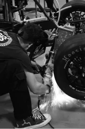 Photo of Owen using an angle grinder on the electric car.